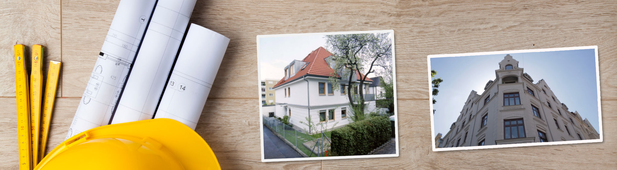 Aufgerollte Baupläne, ein Meterstab sowie ein Bauhelm liegen auf einem Holzboden. Daneben liegen Fotos von einem Neubaus eines Mehrfamilienhauses sowie von einer frisch renovierten, historischen Fassade
